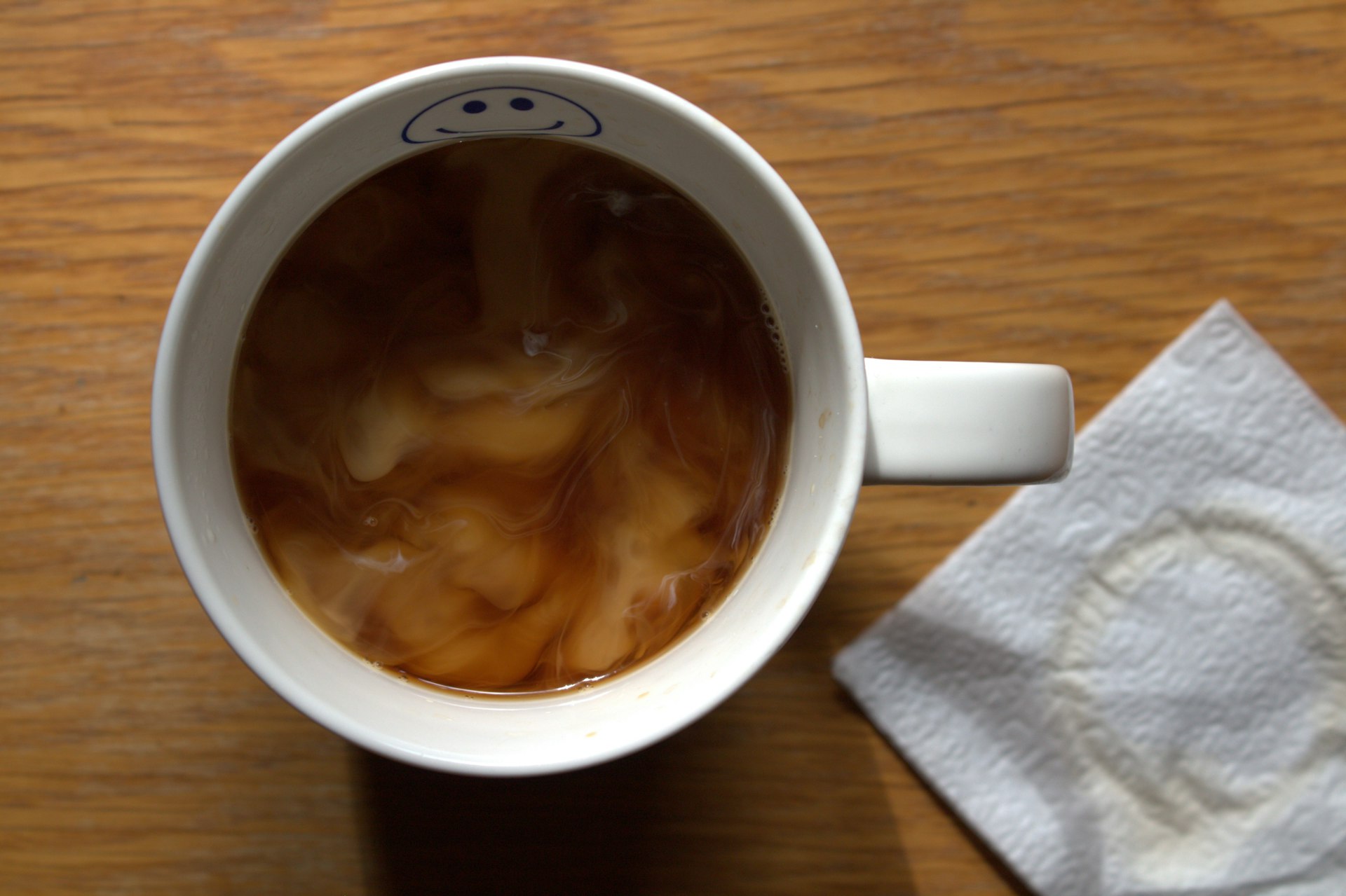 A cup of coffee and a napkin on a table